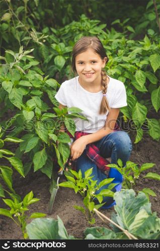 Happy young woman working at garden with trowel