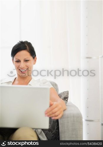 Happy young woman working on laptop