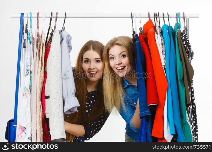 Happy young women during shopping time picking clothes for perfect fashionable outfit.. Happy women clothes shopping
