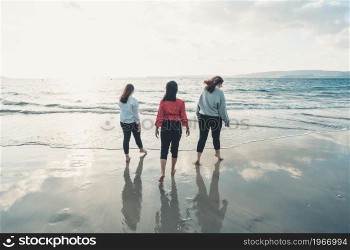 Happy young women laughing and smiling at the beach on a summer day, enjoying vacation, concept of friendship enjoying the outdoor