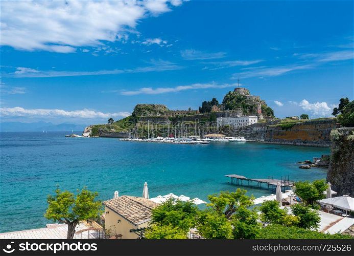 Harbor and yachts by Old Fortress in the town of Corfu. Old Fortress of Corfu on promontory by old town