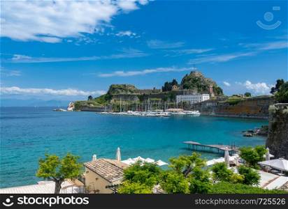 Harbor and yachts by Old Fortress in the town of Corfu. Old Fortress of Corfu on promontory by old town