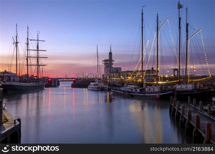 Harbor from Harlingen with decorated sailing boats in Friesland the Netherlands at sunset
