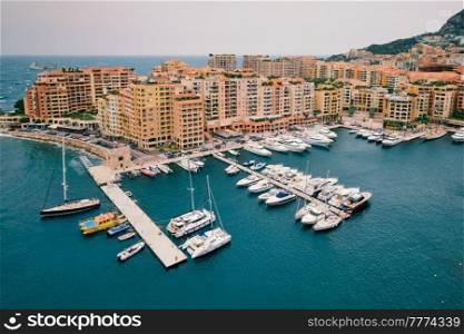 Harbor with moored yachts and boats and residential houses in Moncte Carlo, Monaco. Harbor with yachts and boats in Moncte Carlo, Monaco
