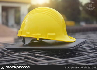 Hard hat safety on computer notebook building construction estate background