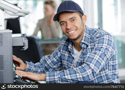 hardware repairman repairing broken printer fax machine