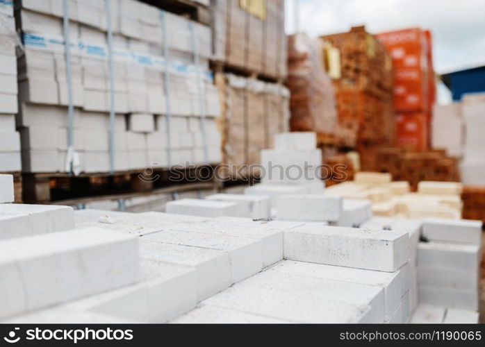 Hardware store assortment, packs of bricks outdoor, nobody. Building materials and tools choice in diy shop, rows of products