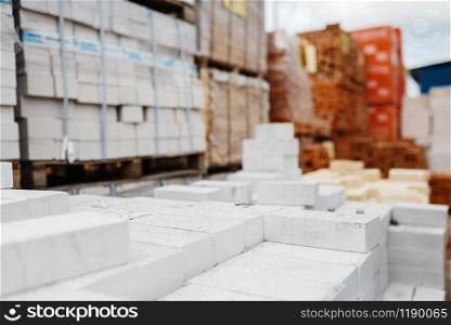 Hardware store assortment, packs of bricks outdoor, nobody. Building materials and tools choice in diy shop, rows of products