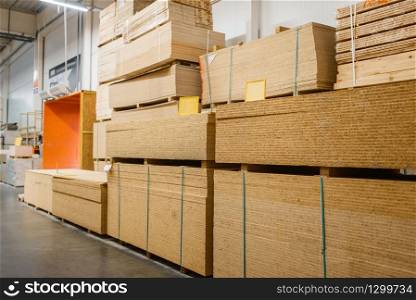 Hardware store assortment, packs of chipboard, nobody. Building materials choice in diy shop, rows of products on racks. Hardware store assortment, packs of chipboard
