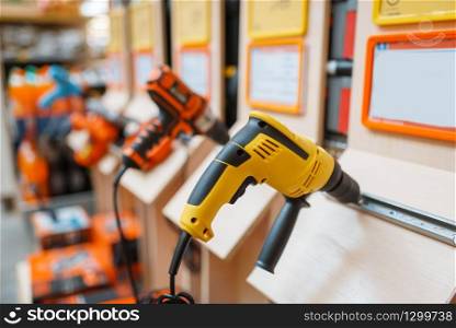 Hardware store assortment, shelf with electro drills, nobody. Power tools choice in diy shop, rows of products, electric instrument