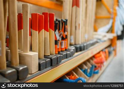 Hardware store assortment, shelf with hammers, nobody. Building materials and tools choice in diy shop, rows of products on racks. Hardware store assortment, shelf with hammers