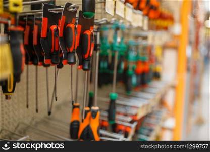 Hardware store assortment, shelf with screwdrivers, nobody. Building materials and tools choice in diy shop, rows of products on racks