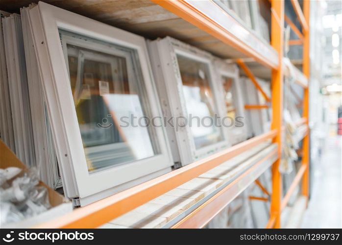 Hardware store assortment, shelf with windows, nobody. Building materials choice in diy shop, rows of products on racks