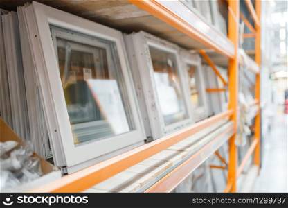 Hardware store assortment, shelf with windows, nobody. Building materials choice in diy shop, rows of products on racks
