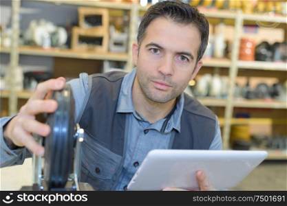 hardware worker checking tablet to fix an issue