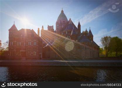 Harlem Cathedral of Saint Bavo  St. Bavo Kathedraal  with sun flare, view over canal. Haarlem, Netherlands. Cathedral of Saint Bavo, Harlem, Netherlands