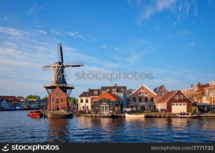 Harlem cityscape - landmark windmill De Adriaan on Spaarne river with boats. Harlem, Netherlands. Panorama of Harlem, Netherlands