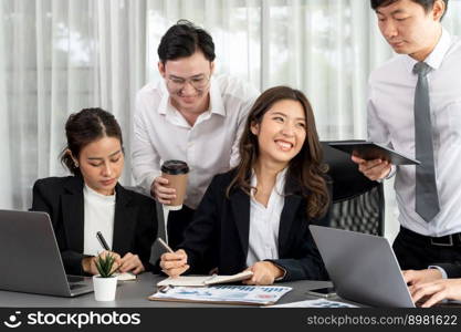 Harmony in office concept as business people analyzing dashboard paper together in workplace. Young colleagues give ideas at manager desk for discussion or strategy planning about project.. Office worker and manager analyze financial report paper in harmony workplace.