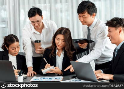 Harmony in office concept as business people analyzing dashboard paper together in workplace. Young colleagues give ideas at manager desk for discussion or strategy planning about project.. Office worker and manager analyze financial report paper in harmony workplace.