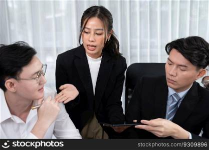 Harmony in office concept as business people analyzing dashboard paper together in workplace. Young colleagues give ideas at manager desk for discussion or strategy planning about project.. Engaging businesspeople working at desk together as concept of harmony in office