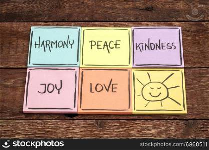 harmony, peace, kindness, joy and love with sun smiley - set of sticky notes with inspirational words against rustic wood