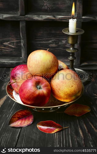 Harvest autumn apples. Still life with autumn harvest apples and candlestick with candle