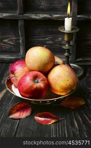 Harvest autumn apples. Still life with autumn harvest apples and candlestick with candle