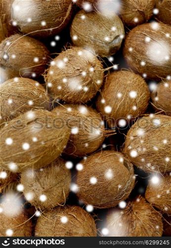 harvest, food and agriculture concept - close up of coconuts over snow. close up of coconuts
