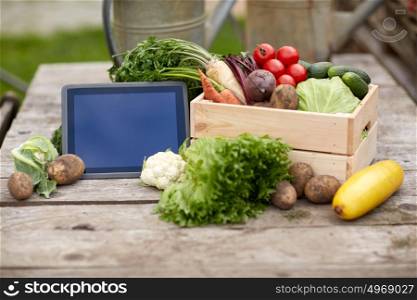 harvest, food and agriculture concept - close up of vegetables with tablet pc computer on farm. close up of vegetables with tablet pc on farm