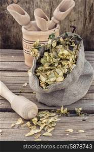 harvest hop cones cut. bag of harvest of dried hop cones in rustic style on wooden background
