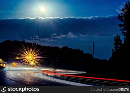 harvest moon glowing over busy highway traffic