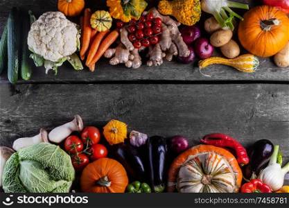 Harvest of many vegetables on rustic wooden table background border frame with copy space for text. Harvest on wooden background