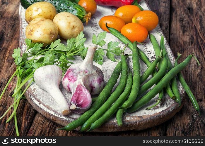 Harvest of summer vegetables. Fresh vegetables. Composition with assortment raw vegetables.Beans in pods, basil, orange tomato, pepper and potatoes