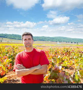 Harvester winemaker farmer proud of his vineyard in autumn golden red leaves at Mediterranean