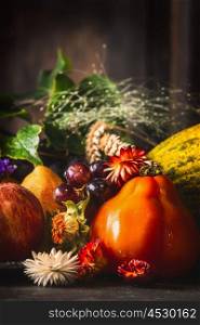 Harvesting fruits and vegetables on dark rustic kitchen table at wooden background, side view, close up