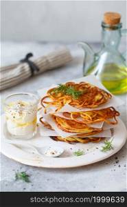 Hash brown potato with white sauce. Potato Pancakes. delicious Vegetable fritters. Potato patties or hash browns. Crispy hashed browned potatoes