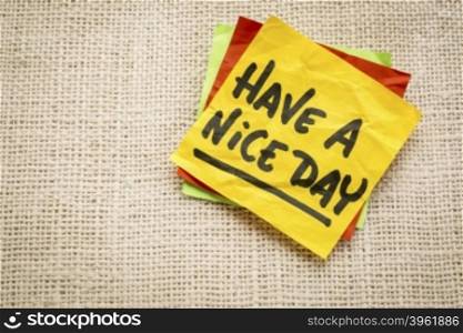 Have a nice day - handwriting on a sticky note against burlap canvas