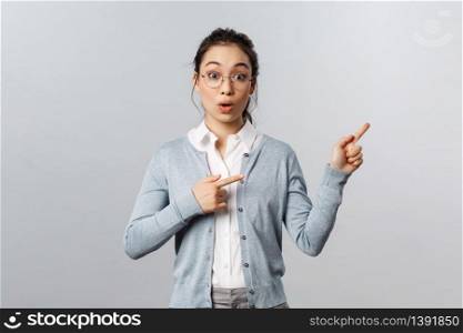 Have you seen it already. Impressed and excited asian girl, teacher pointing fingers right as telling about incredible news, event going nearby, inviting take a look, ask question about product.. Have you seen it already. Impressed and excited asian girl, teacher pointing fingers right as telling about incredible news, event going nearby, inviting take a look, ask question about product