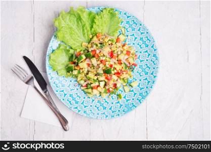 Hawaii style vegetarian raw eating salad/ served in beauiful blue plate on white table. flat lay