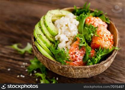 Hawaiian poke coconut bowl with grilled salmon fish, rice and avocado. Healthy food