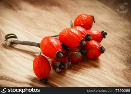 Hawthorn on wooden rustic table background. Rose hips haw fruit of the dog rose.