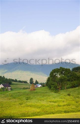 Haystack summer in the beautiful village Ukrainian Carpathians. Carpathian nature in summer