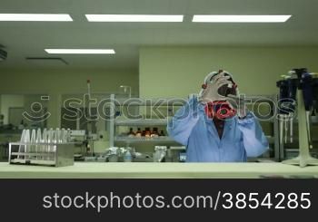 Hazardous and dangerous job, biotech and pharmaceutical lab with researcher wearing mask and checking vaccine