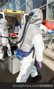 Hazardous material medical team with equipment walking towards contaminated building