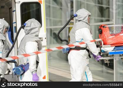 Hazardous material medical team with stretcher entering contaminated building