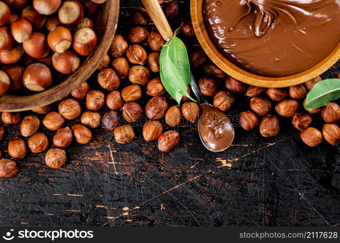 Hazelnut butter in a spoon on the table. On a rustic dark background. High quality photo. Hazelnut butter in a spoon on the table.