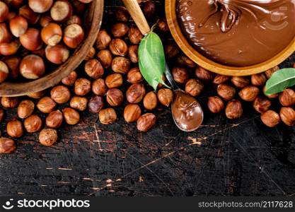 Hazelnut butter in a spoon on the table. On a rustic dark background. High quality photo. Hazelnut butter in a spoon on the table.