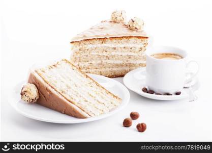 hazelnut cream cake with coffee. hazelnut cream cake with a cup of coffee and three hazelnuts on white background