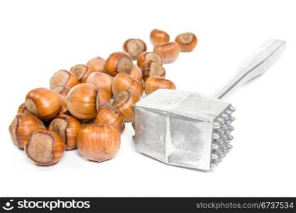 hazelnuts and metal hammer over a white background