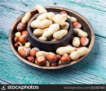hazelnuts and peanuts. nut peanuts,hazelnuts in the shell and chipped in a bowl